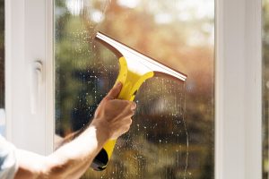 hand cleaning window with vacuum cleaner